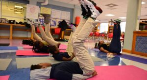 School yoga session kids on back with feet up in air
